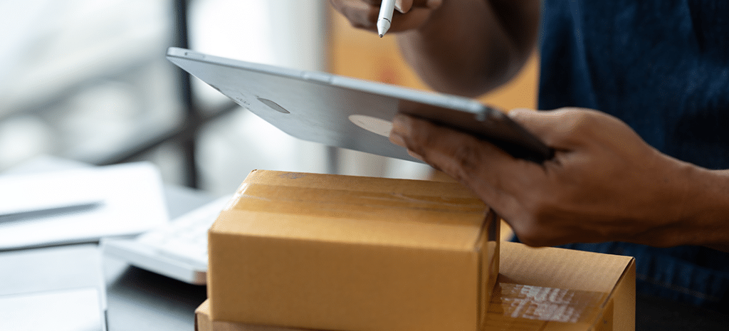 a warehouse worker checks the shipping specifications for a package. WordPress dropshipping