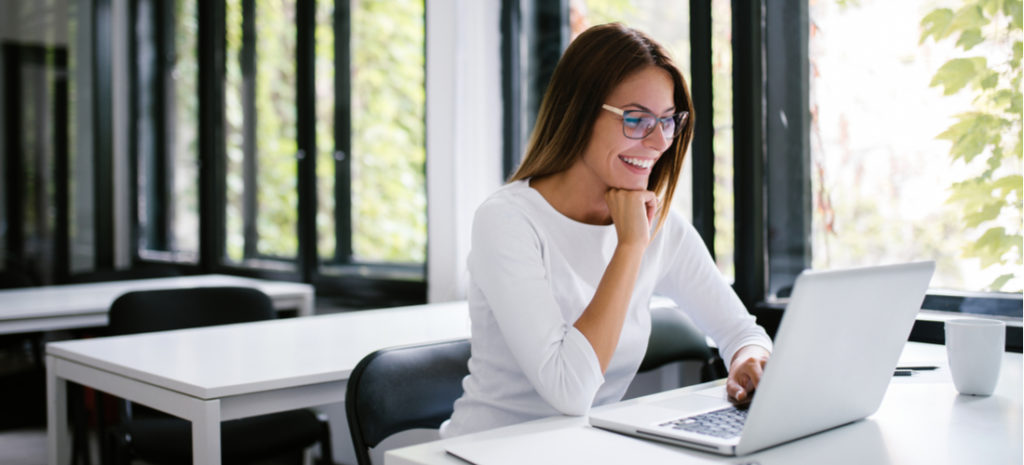 smiling woman looking at laptop
