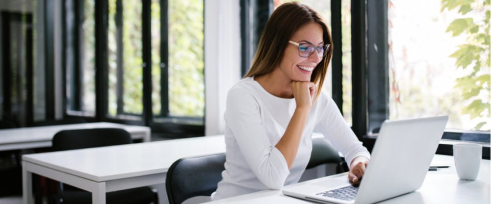 smiling woman looking at a WordPress wiki on her laptop