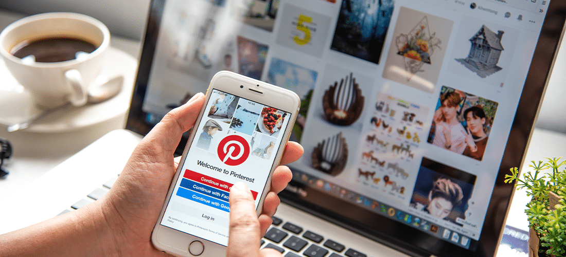 pinterest login screen on mobile device with pinterest page on desktop in background
