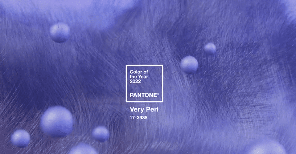 promotional image in Pantone shade Very Peri. The background has a fuzzy texture and small spheres float in the foreground