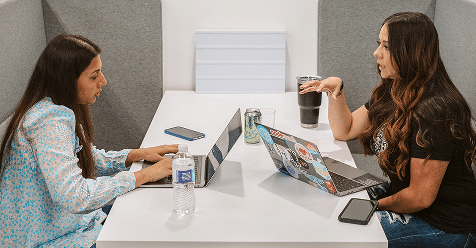 Designer and client discussing a project across from one another at a table