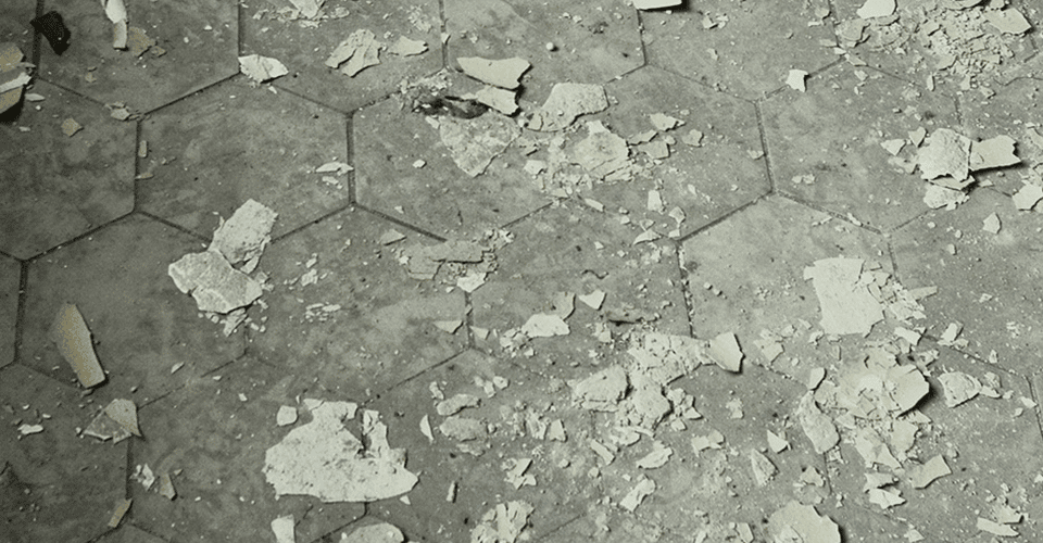 paint chips strewn across a floor comprised of hexagonal stones