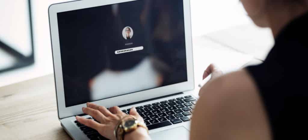 woman typing password on laptop